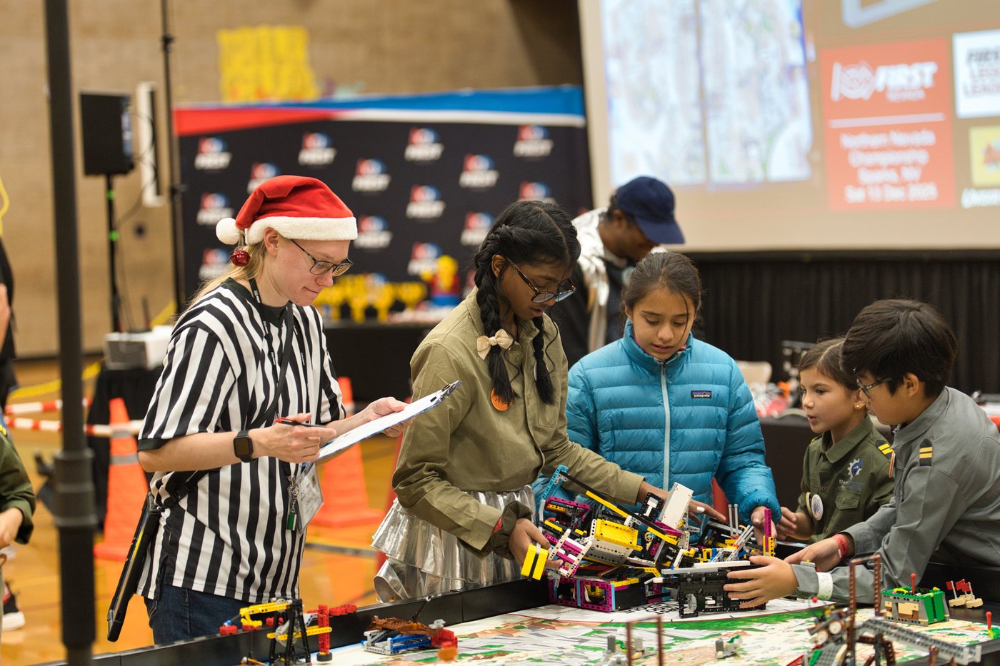 Reno Rovers students and a reviewer gathered around a robot game table