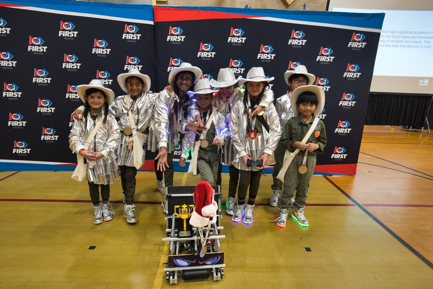 Reno Rovers students in rover costumes standing with their robot at a FIRST event